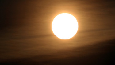 Wüstensand verschleiert die Sonne. Mehrmals pro Jahr zieht Sand aus den Wüsten Afrikas bis zu uns. Der rötliche Saharastaub trübt die Sonne und kann für "schmutzigen" Regen sorgen. | Bild: picture-alliance/dpa